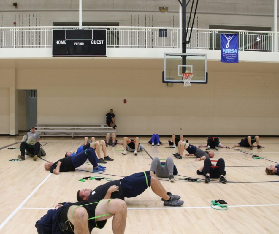 Individuals are doing exercises on basketball court