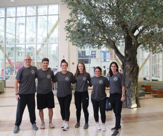 Members of Tactical Athlete Initiative group pose for picture in front of tree on the inside of the RAC lobby